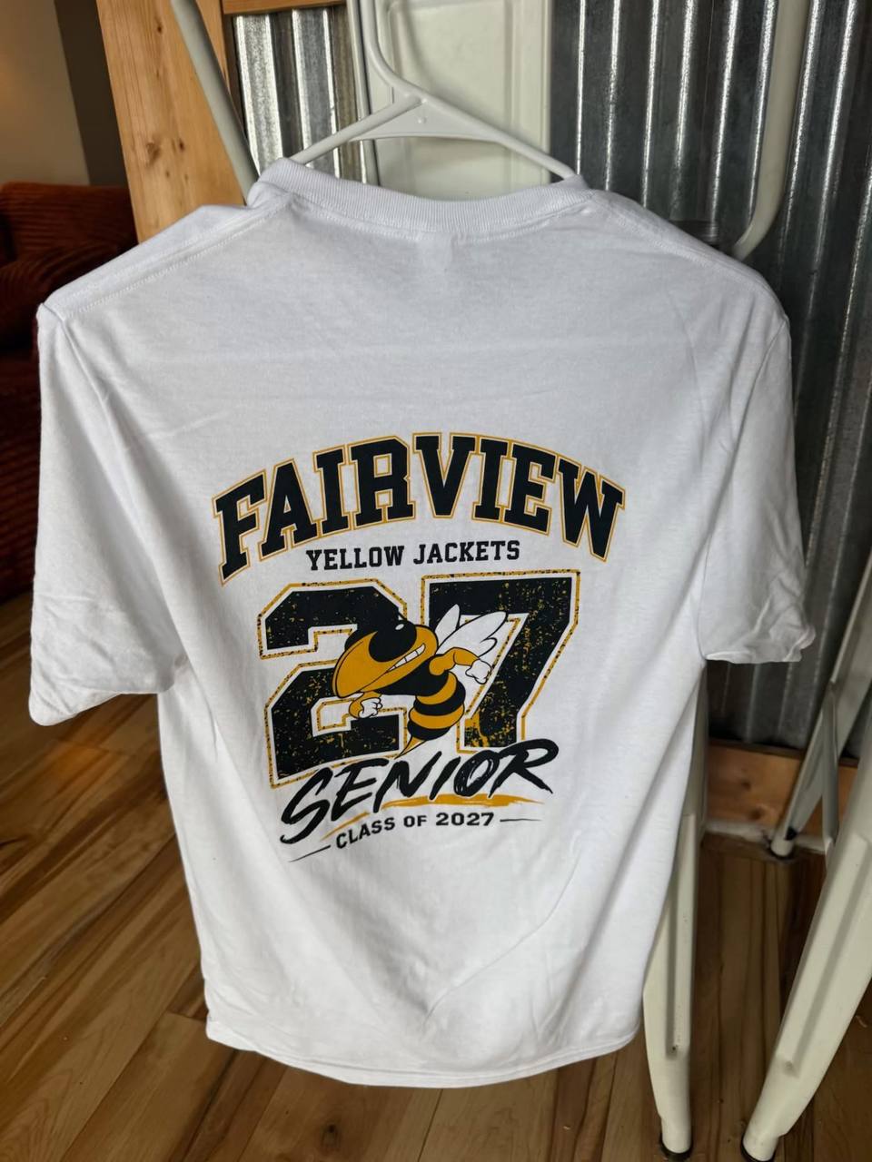 A white T-shirt on a hanger reading Fairview Yellow Jackets, Senior, Class of 2027, with a yellow jacket mascot graphic.