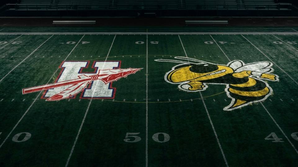 The Harpeth Indians and Fairview Yellow Jackets logos painted at midfield on a football field.