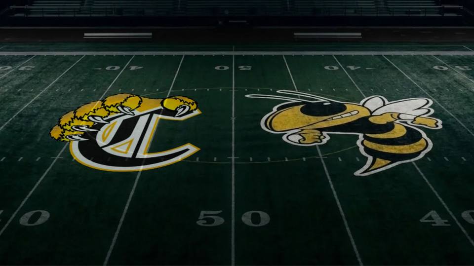 The Camden Central Lions and Fairview Yellow Jackets logos painted at midfield on a football field.